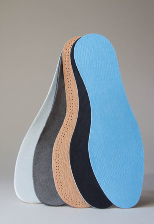 Insoles of different colors and different textures on neutral background. foot care products.