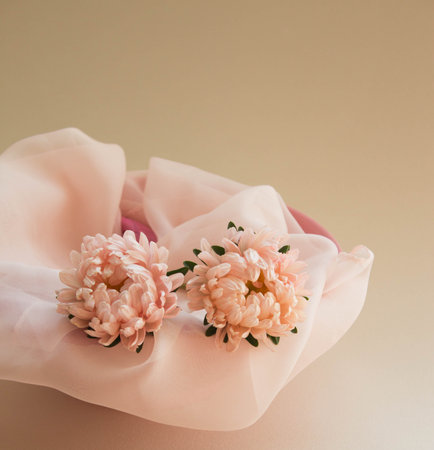 Asters flowers with silk scarf. Elegant floral arrangement of pink garden flowers on beige background.の写真素材