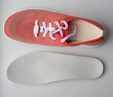 Orange sport shoes with orthopedic insoles on neutral background.. Top view.の写真素材