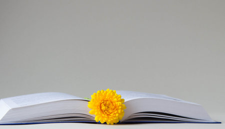 Opened book with bookmarks from calendula flower on a light neutral background. Copy space.