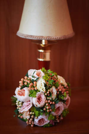 The bride's rose bouquet next to the lampの写真素材