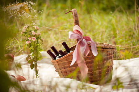 basket with wine in a forest glade on warm Sunny dayの写真素材