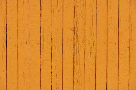 Orange flaky paint on a wooden fence.の写真素材