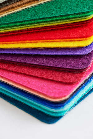 Felt fabric sheets in various colors piled up in a stack.の写真素材