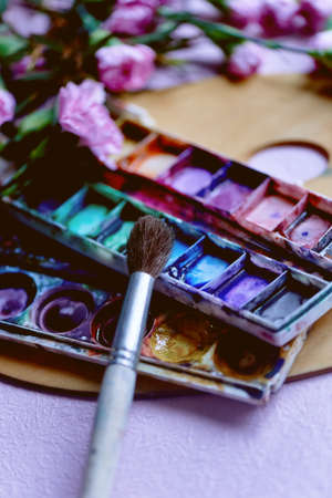The workplace of the artist. Paint brush and pink carnations Still life composition of artistic workplaceの写真素材