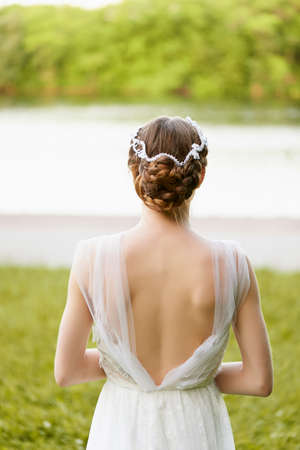Beautiful slim girl in white long dress with open backの写真素材