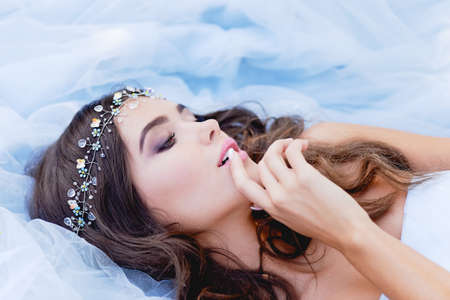 Gorgeous brunette with closed eyes touches her lipsの写真素材