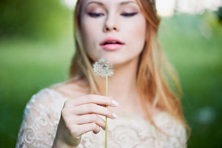 Girl blowing on a dandelion, ease and tenderness. the smile on the face