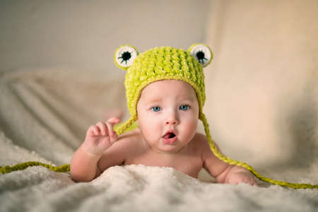 Little newborn baby with a light fluffy blanket in a cute hatの写真素材