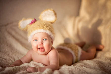 Little newborn baby with a light fluffy blanket in a cute hatの写真素材
