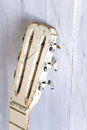 The fretboard of an old guitar, painted in cream paint. Closeの写真素材