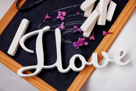 Wooden slate with chalk and vintage scissors . Lilac purple, The inscription I love.