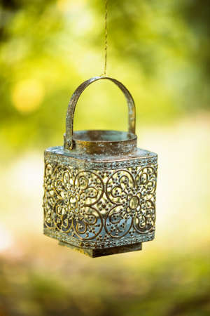 Golden candle holder hanging on green background. The decor for the wedding photo shootの写真素材