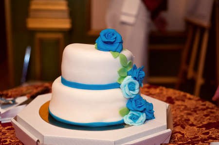 Wedding cake in white frosting with blue and turquoise roses. Closeの写真素材