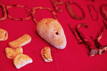 Clay fragments and a stone with a hole discovered during excavations on a red cloth