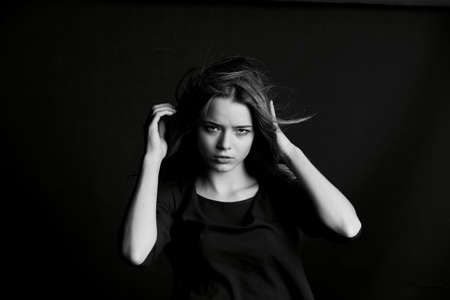 Skinny tall girl of model appearance, touching their hair.の写真素材