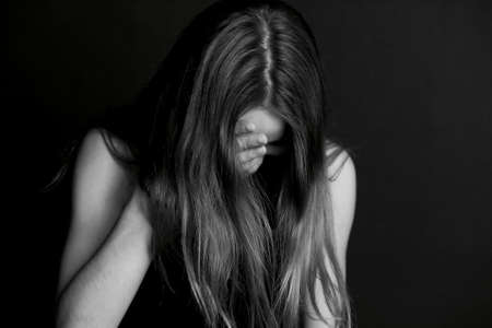Shame, shyness or confusion. Girl hiding face with hair