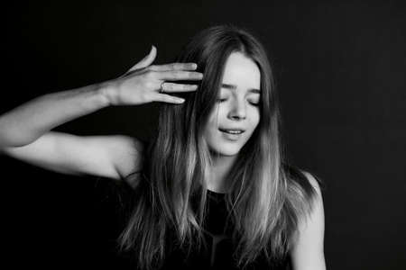 Skinny tall girl of model appearance, touching their hair.の写真素材