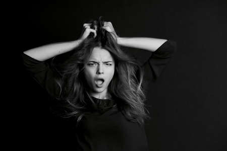 A young girl with long hair. Daring look in . BW