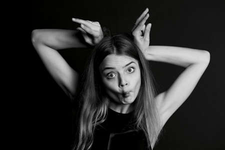 Young beautiful girl builds faces. Hamming , funの写真素材