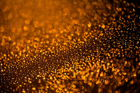 Drops of rain on window with abstract lights. Rain drops on window with road light bokeh, City life in night in rainy season abstract background, water drop on the glass, night storm raining car driving concept.の写真素材