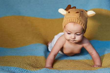 newborn baby with big eyes hat-knitting on a plain background.の写真素材