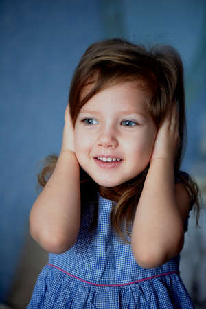 Hear no evil . Baby closes ears hands