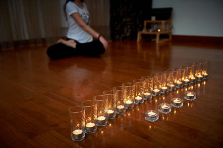 Girl does yoga and relaxation in the warm light of candles. Relaxationの写真素材