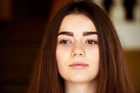 Young girl looking at the camera. Long dark hair and brown eyes .の写真素材