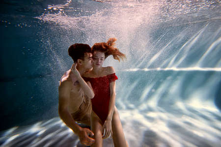 Underwater in the pool with the purest water. Loving couple hugging. The feeling of love and closeness. Softの写真素材