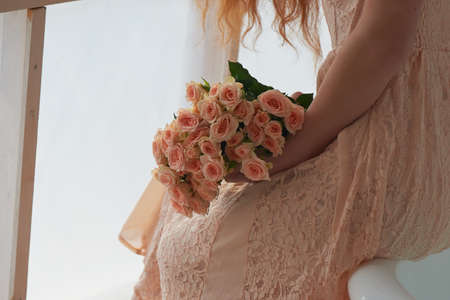 Bouquet of delicate pink spray roses on a background of pink lace dressの写真素材