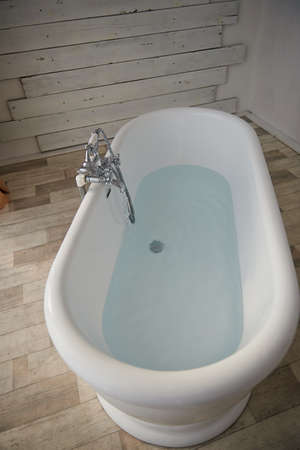 Minimalist bathroom interior. Bath in the middle of the bright room on the window. The view from topの写真素材