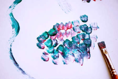 Traces of acrylic paint on a white sheet of paper. Abstract lines prints. The art of color.On the paper in the corner is the brushの写真素材