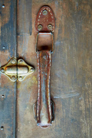 Old worn suitcase handle. Painted gold paint, base color is brown.Stitched threadの写真素材