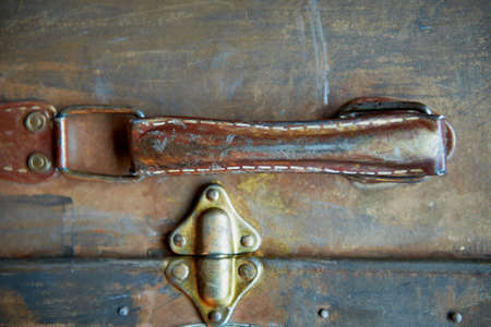 Old worn suitcase handle. Painted gold paint, base color is brown.Stitched threadの写真素材