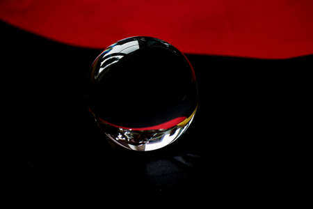 Glass globe or drop of water on a background of red and black velvet paper. Clean and Shineの写真素材