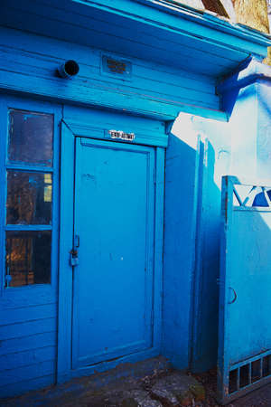 Old door in a wooden house and shed. The inscription above the door polusmerti.Phoneの写真素材