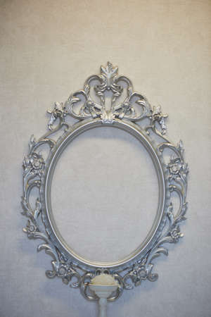 Decorative oval frame hanging on the gray wall.Classic decor, framingの写真素材