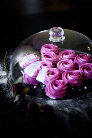 Many purple marshmallow on a dark surface. A contrasting picture. A work of culinary art.Under a glass coverの写真素材