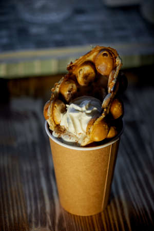 Sweet Hong Kong waffle with fruit and whipped cream in a brown Cupの写真素材