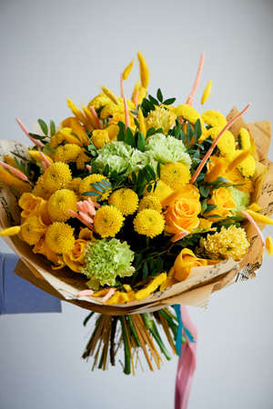 Yellow bouquet with green carnation,in the composition of chrysanthemums, roses and dyed grainsの写真素材