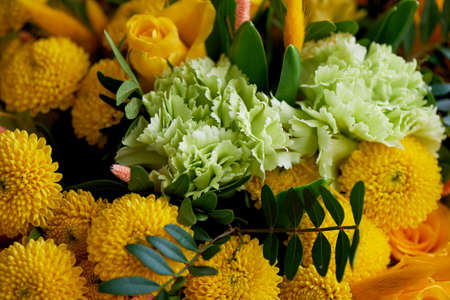 Yellow bouquet with green carnation,in the composition of chrysanthemums, roses and dyed grainsの写真素材