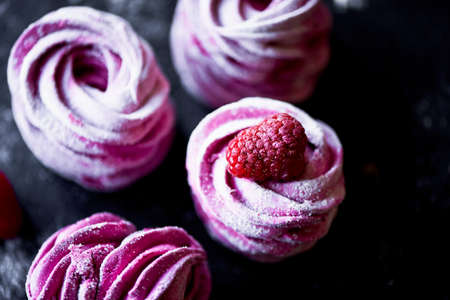 Many purple marshmallow on a dark surface. A contrasting picture.A work of culinary art
