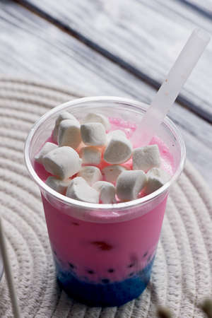 bubble tea in pink and blue color in a plastic Cup with a straw. The top is sprinkled with marshmallows.Soft, beautiful colorsの写真素材