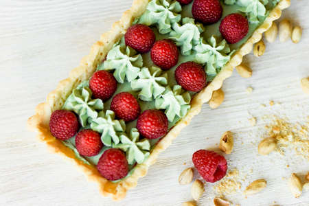 Pistachio tart. Pistachio tart on white Belgian chocolate BARRY with a layer of raspberry confit,...