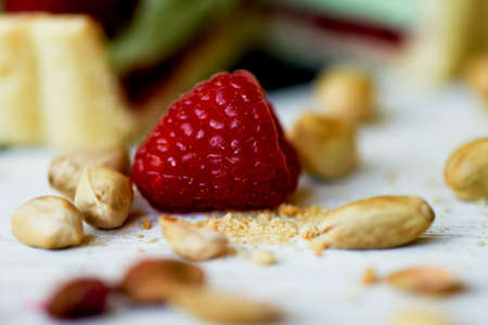 Pistachio tart. Pistachio tart on white Belgian chocolate BARRY with a layer of raspberry confit, crispy shortbread base, fading cream and juicy raspberries.A classic combination in miniature format.の写真素材