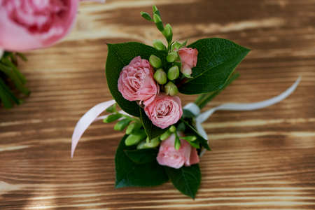 Wedding boutonniere for the groom.A wedding decoration. The greenery and small pink flowerの写真素材