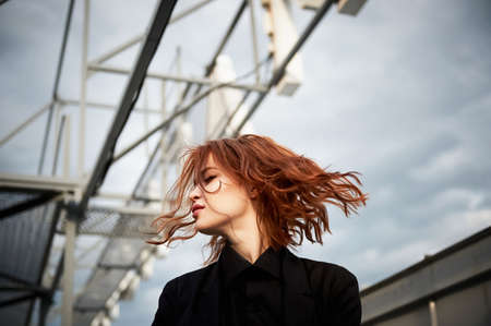 Beautiful red-haired girl with plump lips. Walking around the city. A natural beauty. Roof. Ginger