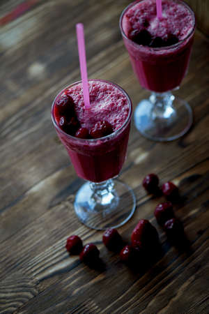 Fresh cool smoothie in a glass with a stem. Delicious and healthy Breakfast. Of cherries and strawberriesの写真素材