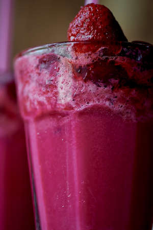 Fresh cool smoothie in a glass with a stem. Delicious and healthy Breakfast. Of cherries and strawberriesの写真素材